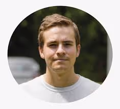 A man in a white shirt is looking at the camera.